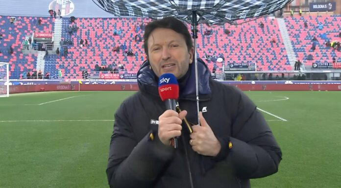 L'inviato Sky Sport, alle prese con un ombrello piegato dal vento.