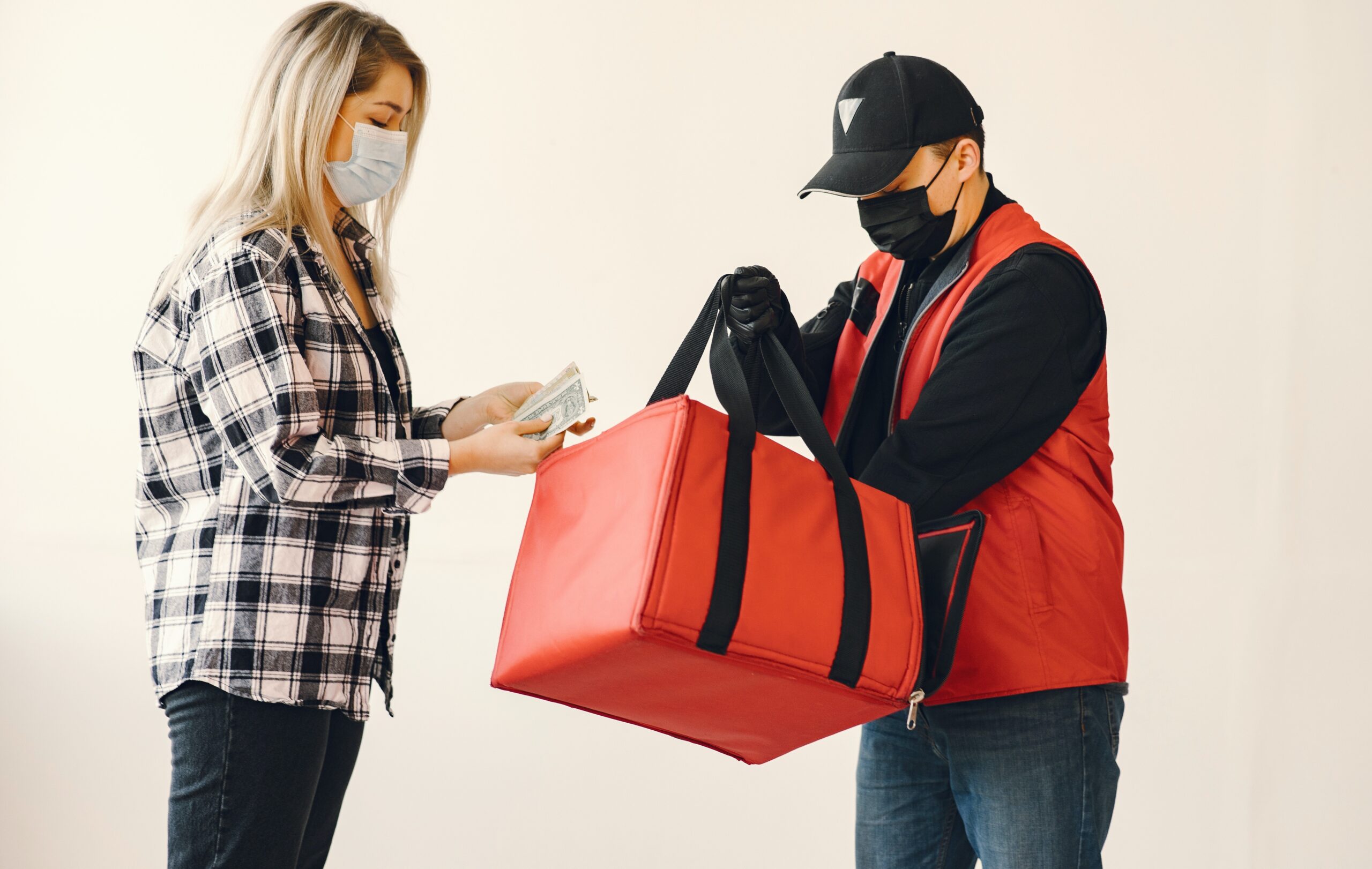 Un corriere consegna del cibo a domicilio a una cliente. Foto stock